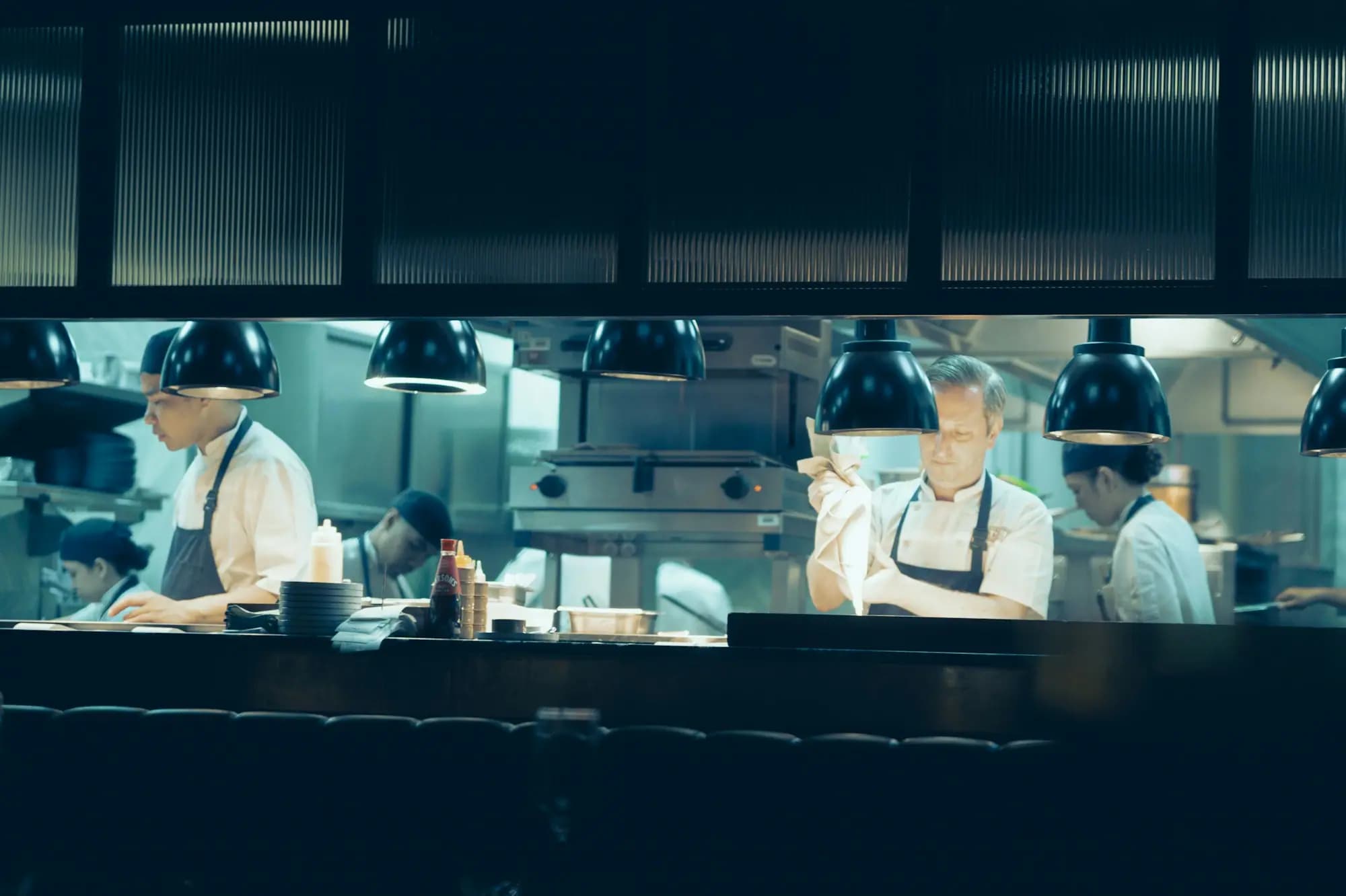 Equipo de un restaurante trabajando coordinado en la cocina durante el servicio