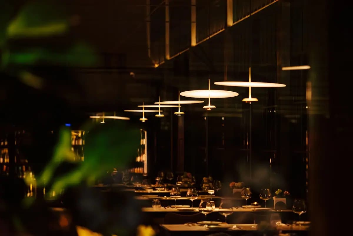 Interior de restaurante moderno con mesas servidas y luces colgantes