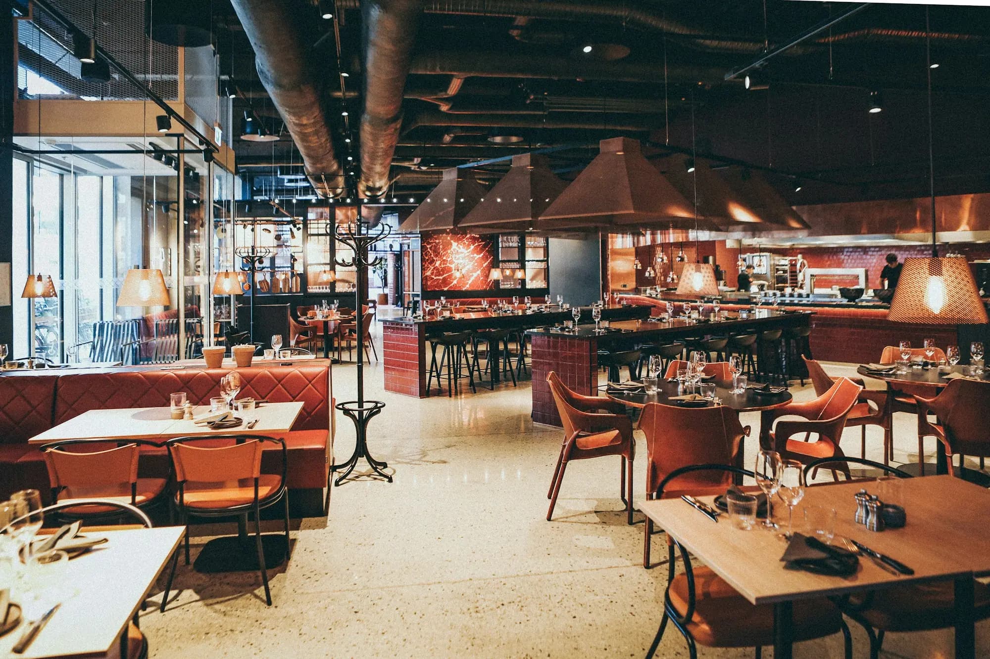 Salón de un restaurante con luces cálidas, listo para el siguiente servicio