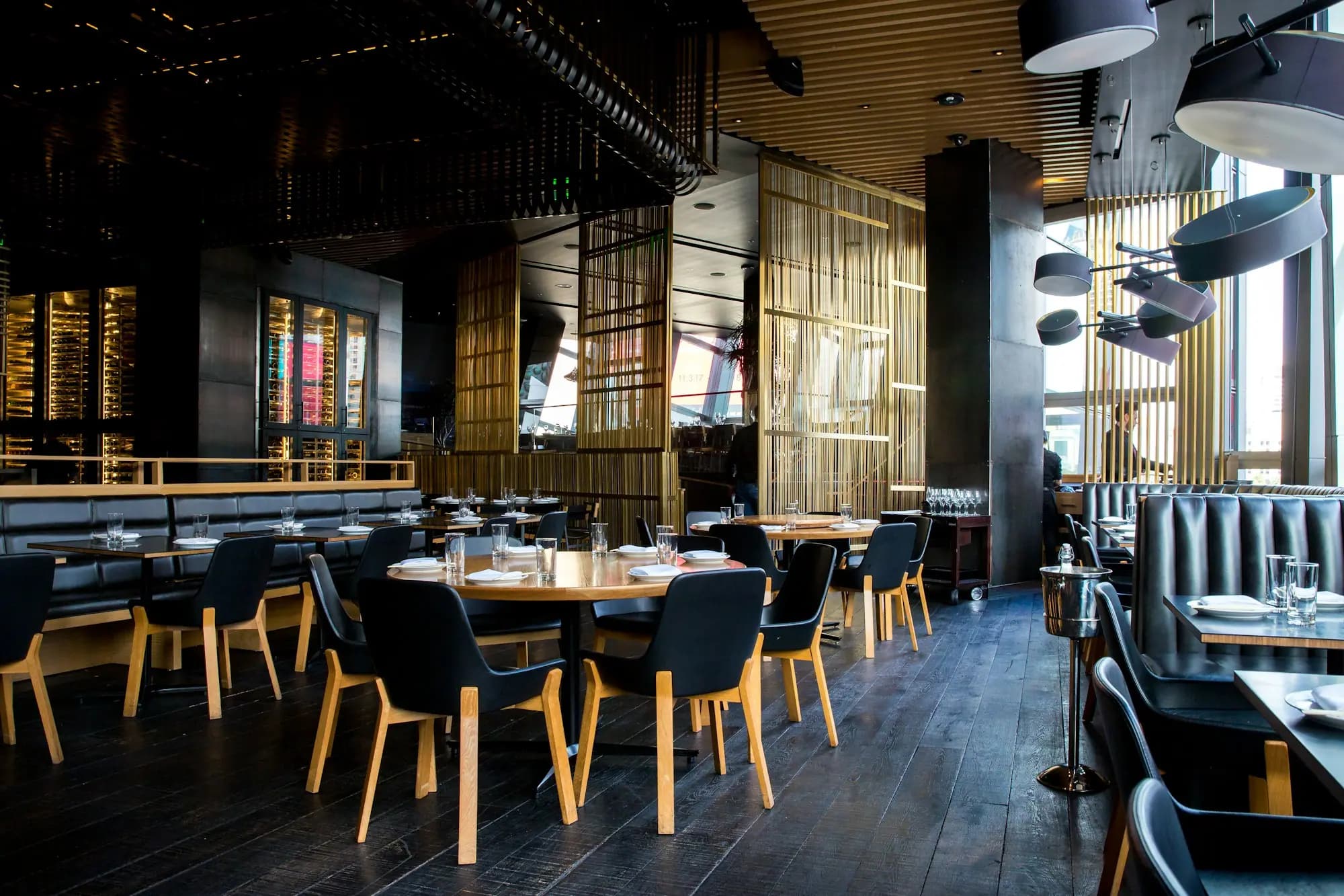 Salón de un restaurante en penumbra con las mesas listas para el siguiente servicio